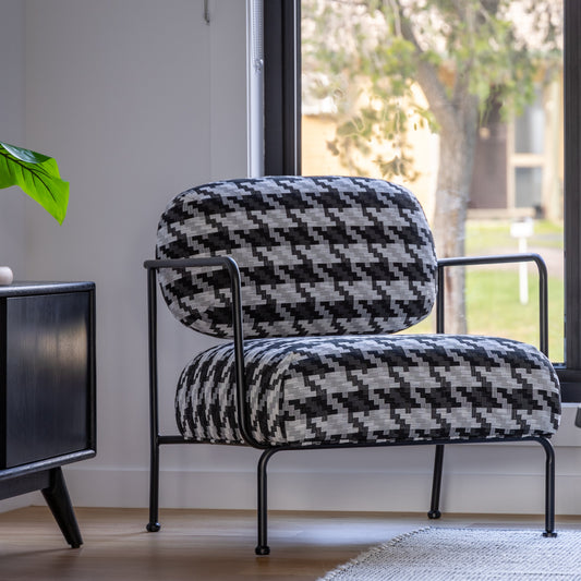 Houndstooth patterned upholstered armchair with padded seat and modern frame.