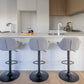 Bar stools beside a white marble counter